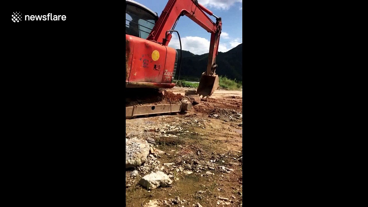 Skilled digger driver uses arm to fix broken machine