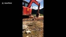Skilled digger driver uses arm to fix broken machine