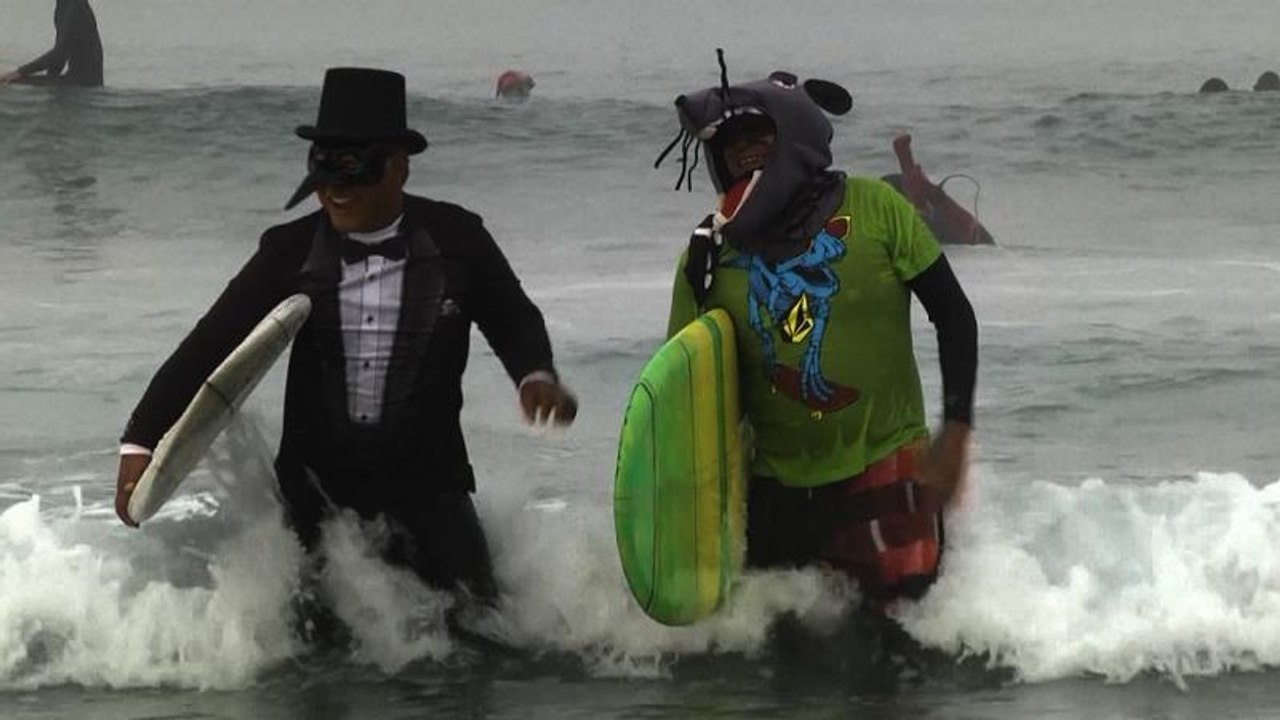 Surfistas disfrazados festejan Halloween sobre las olas en Newport Beach