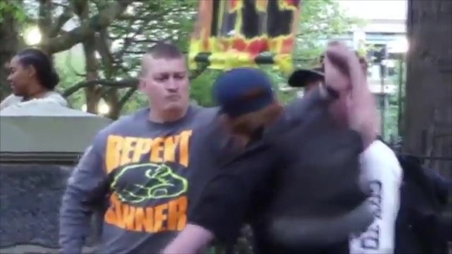 Un prêcheur de rue attrape un coup de poing qu'un jeune essaye de donner