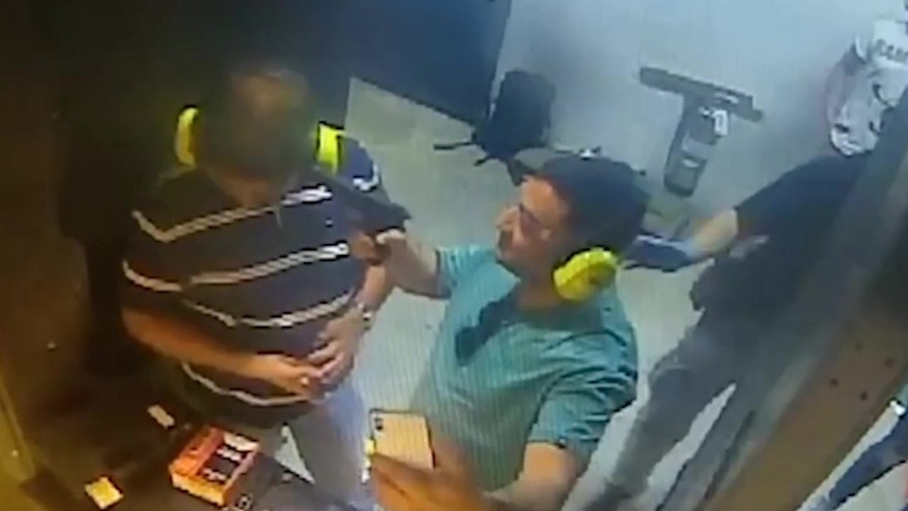 Un idiot pointe une arme chargée sur la tête de son pote pour faire une photo dans un stand de tir