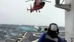 Un hélicoptère tente d'atterrir sur un bateau en pleine tempête