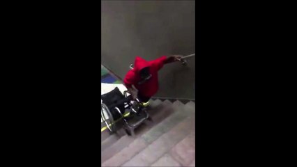 Cet handicapé doit porter son fauteuil roulant pour monter les escaliers du métro