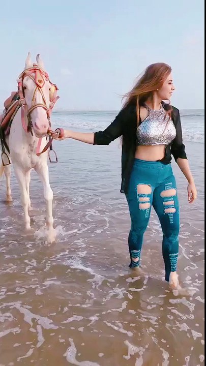 Beautiful girl walk on beach with her horse