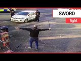 Police confront man waving ‘samurai sword’ on a street in broad daylight | SWNS TV