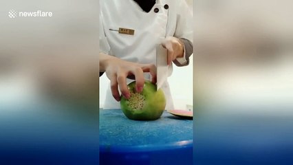 Chef uses cleaver to finely carve radish into netting