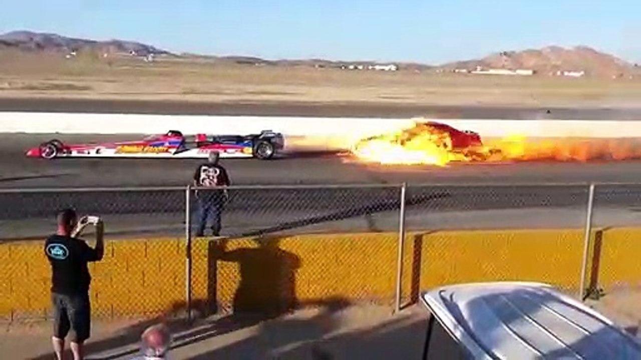 Un dragster brûle une voiture en mettant les gaz.