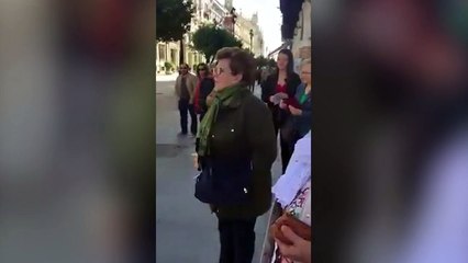 Una señora le canta a un estatuista disfrazado de Jesús