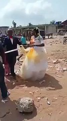 Une femme verse de l'huile de palme sur la nouvelle épouse de son mari le jour du mariage