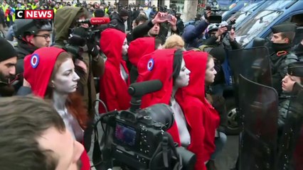 Des femmes habillées en Marianne font face aux forces de l'ordre