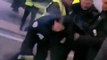 Un policier met une grenade lacrymogène dans la veste d’un gilet jaune.