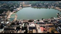 Pushkar town, lake and Aravalli hills- aerial journey over tourist town with dense housing