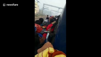 Indian students forced to cling to outside of train to sit police exam