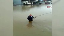 Adana'da bir vatandaş sağanak sonrası su birikintisine girip, balık tutmaya çalıştı
