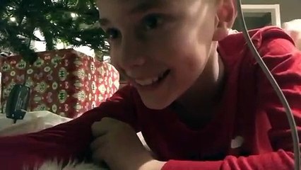 Un enfant place une caméra sous le sapin pour filmer le Père Noël