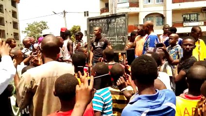 Il dispense un cours sur la voie publique à Koloma sur l'axe Bambeto Cosa