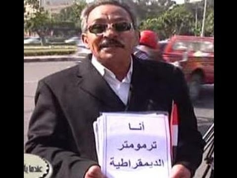 فيديو لمرشح الرئاسة الدكر امام لجنة الانتخابات يحمل لافتة انا ترمومتر الديمقراطية واحد الجماهير يرد كفايا تخلف