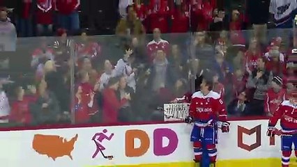 Un joueur de hockey offre un palet à une supportrice qui fond en larmes