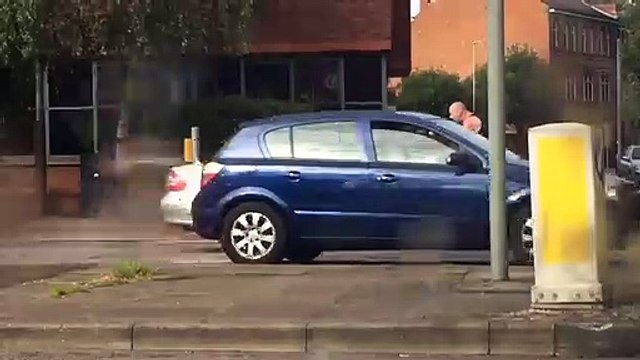 Un dingue cogne sur le pare brise d'une voiture à mains nues