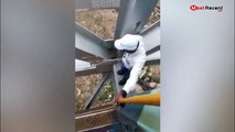 رجل شجاع يخاطر بحياته لإصلاح قطار تعطل فوق أعلى جسر حديدي