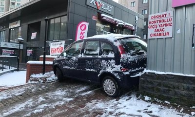 Buzlu yolda kayan otomobil site girişine sıkıştı
