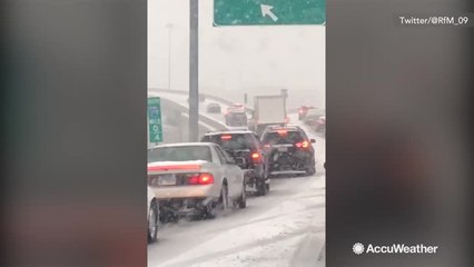 Cars struggle up snowy highway ramp causing backup