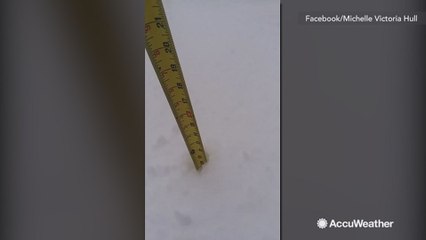Woman measures how much snow has fallen, nearly reaches a foot