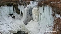 Stunning view of water racing over partially frozen waterfall