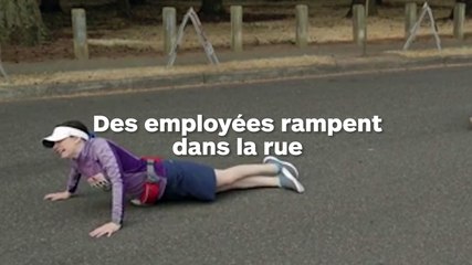 Des employées marchent à quatre pattes dans la rue