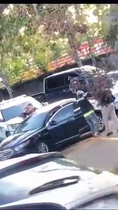 Un bébé marche mains en l'air vers la police armée après l'arrestation de ses parents