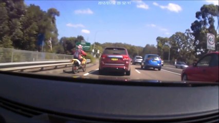 Un automobiliste agacé par le comportement d'un motard tente de le faire tomber