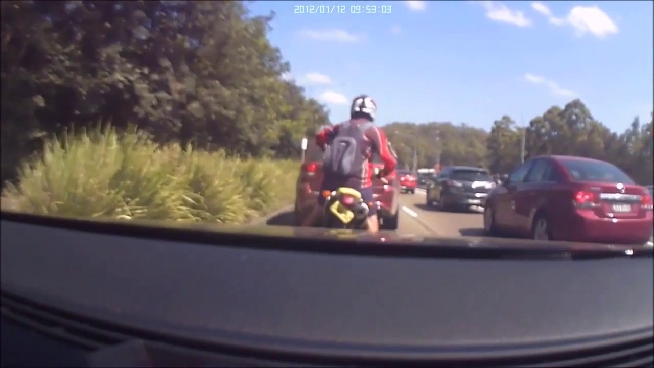 Agacé par un motard, un automobiliste tente de le faire tomber