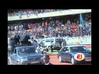 Uhuru waves the crowd aboard a ceremonial Land Rover