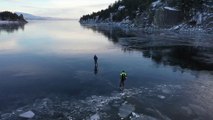 Ils font du patin à glace sur un lac gelé transparent - Canyon Ferry Lake