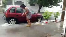CLIP- Tiết kiệm nước, người phụ nữ tranh thủ rửa xe dưới... trời mưa (1)