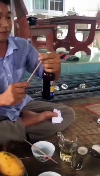 Décapsuler une bière avec une baguette en frappant celle-ci avec la main