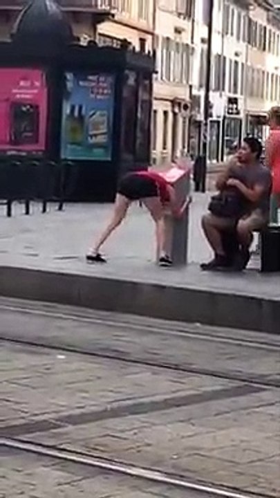 Une fille se retrouve la tête coincée dans une poubelle en pleine rue.