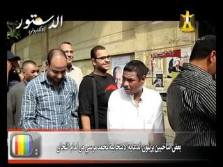 بعض الناخبين يزيلون الدعاية الانتخابية ل مرسي