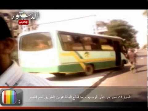 السيارات تعبر من على الرصيف بعد قطع المتظاهرين الطريق أمام القصر