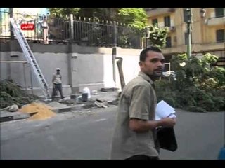 العمال المكلفون بتعلية أسوار الوزراء يحملون لافتات تطالب برحيل مرسي