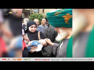 شيخ صوفى يبارك الاطفال خلال احتفالات عاشوراء بـ" الحسين"