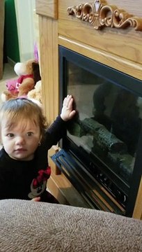 Little baby gives herself kisses in the mirror