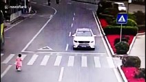 Polite girl bows to car driver after he stops to let her cross the road