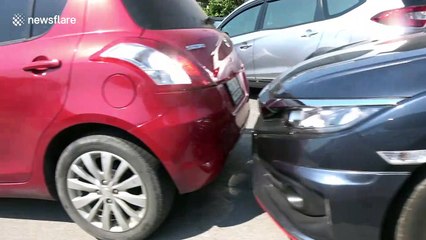 This car park is so packed that drivers have to push vehicles when they want to leave