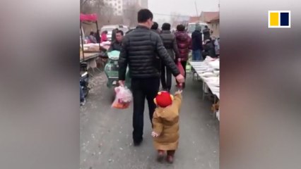 Smart father uses strawberry to lead son through market