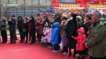 Performers impress visitors by somersaulting on stilts at Chinese temple fair