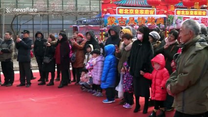 Performers impress visitors by somersaulting on stilts at Chinese temple fair