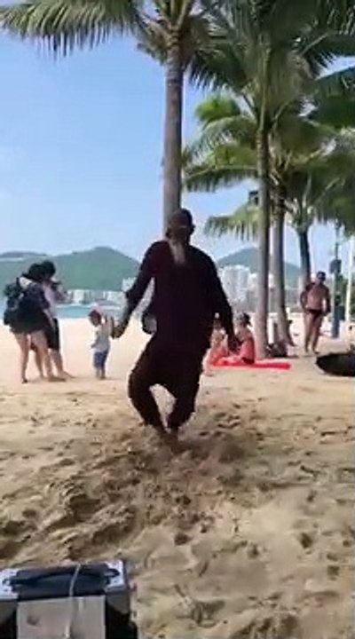 Un homme danse sur la plage