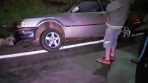 Carro cai em valeta no trevo do Guarujá
