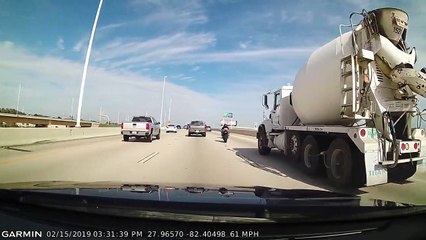 Un motard passe par-dessus une rambarde